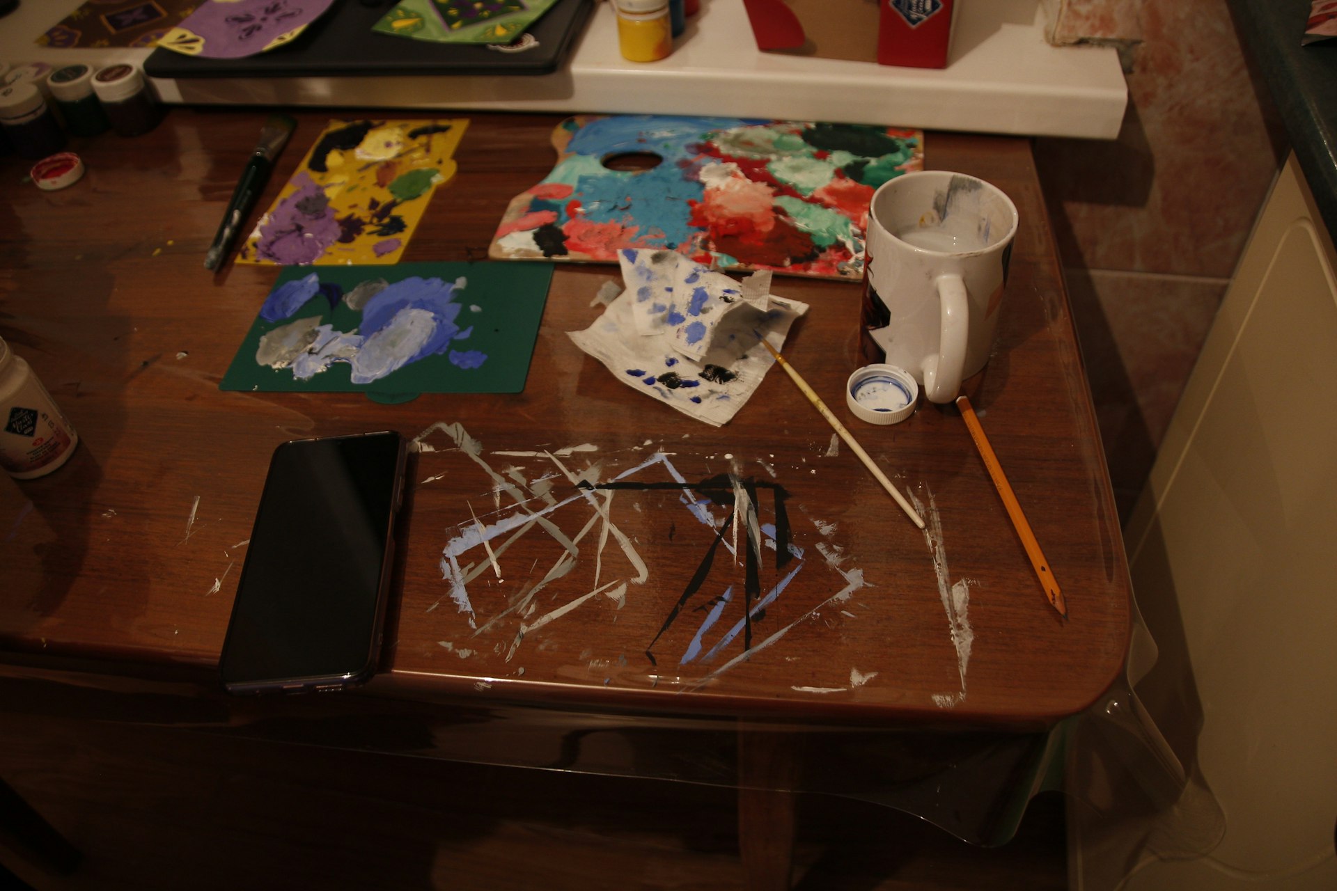 a wooden table topped with lots of art supplies